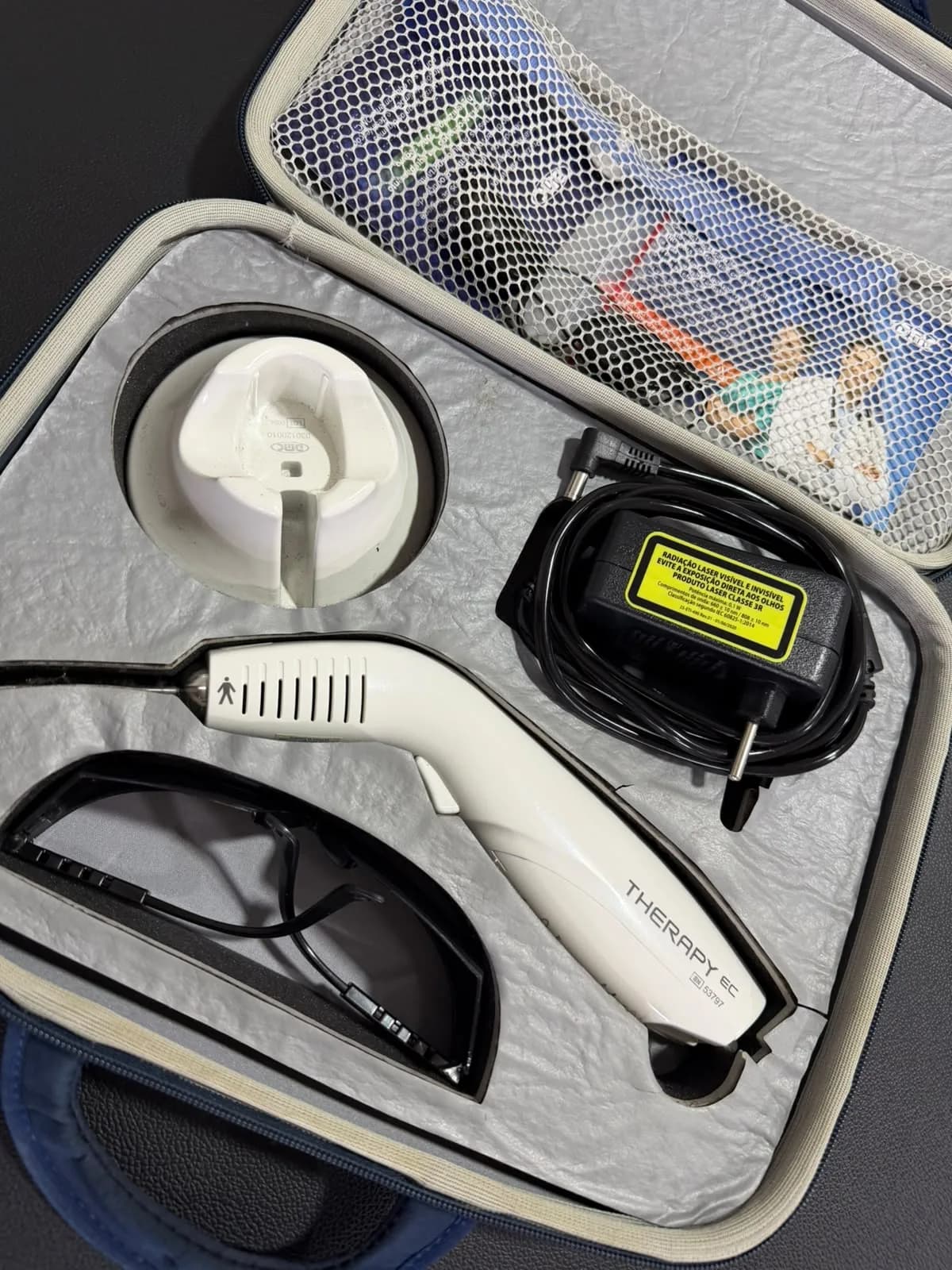 Equipamento de laserterapia da SF Centro Terapêutico, em estojo com óculos de proteção e carregador.